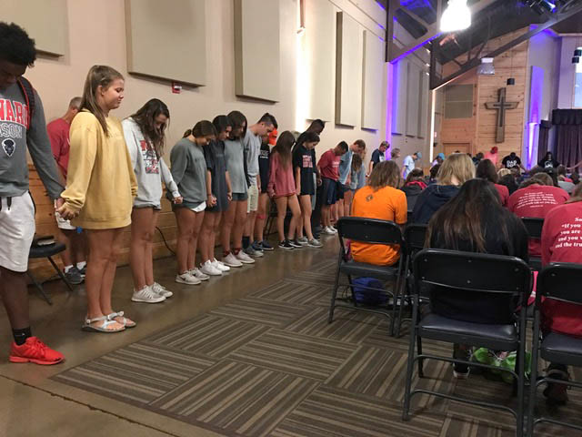 Seniors circle the meeting center to pray over student and staff just before departing for their Senior trip.