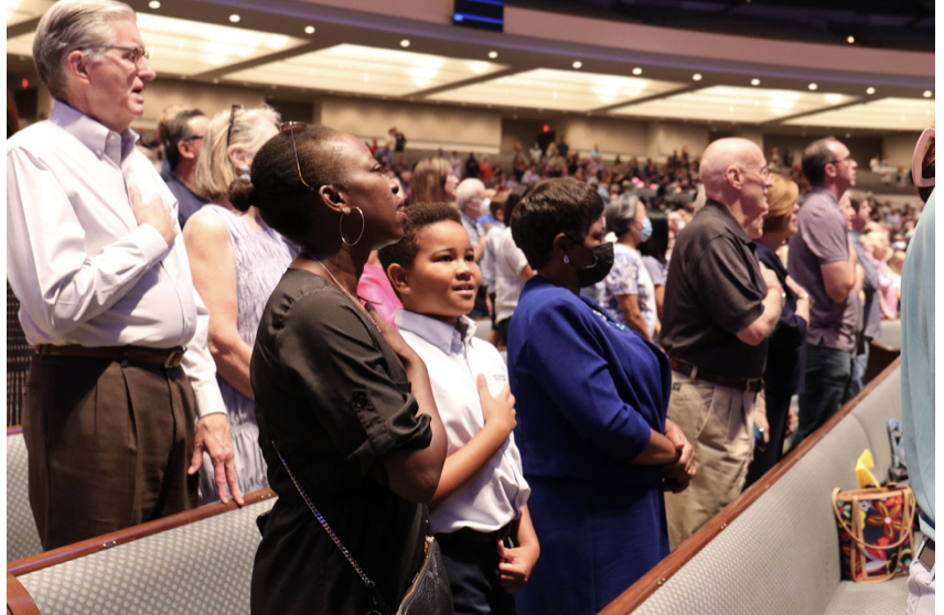 Students and their grandparents perform the pledges together at all school worship.