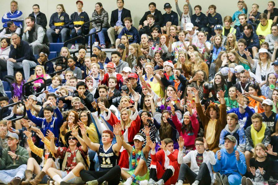 The brightly-colored student section holds hands up waiting for the free throw.