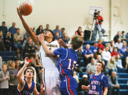 Senior Derrick Flowers flies toward the basket carrying the Trojan defender with him. Derrick came away with 8 points in the 57-37 win over Trinity.