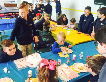 Pre-K students visit the Fifth grade to read the book, The Mitten, and spend time doing activities together.