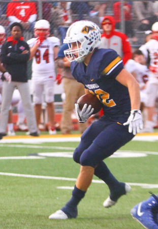 Junior Josh Cunningham runs the ball during the playoff game against St. Thomas. Josh rushed for 113 yards and a touchdown in the game which the Lions won, 42-0.