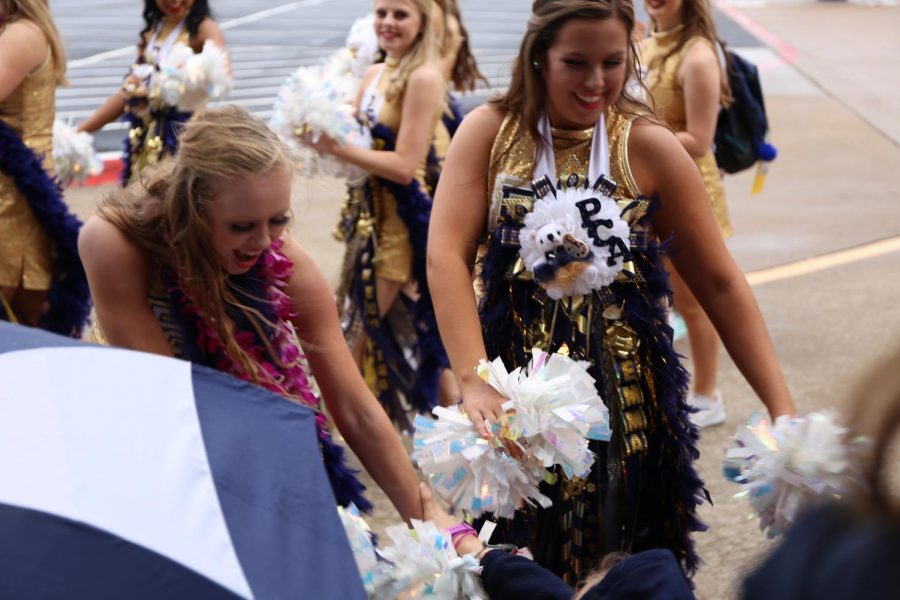 Isabelle Simpson (11) and Emma Stephens (10) greet excited Lower School students at the Homecoming Parade. 