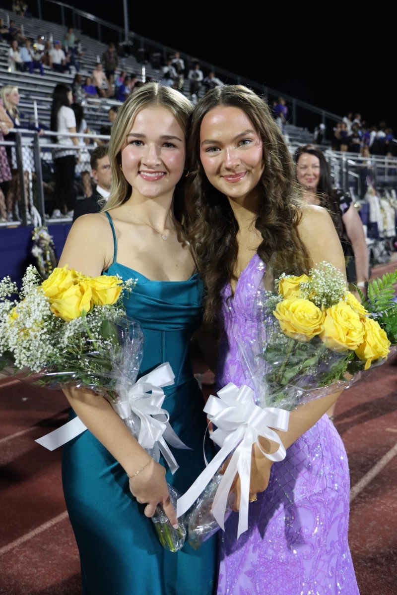 Juniors Hayden Fox and Sophia Allen receiving flowers from loved ones at homecoming court. 