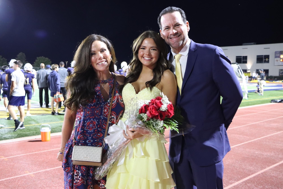 Senior McLayne Powter posing with her parents celebrating homecoming court.